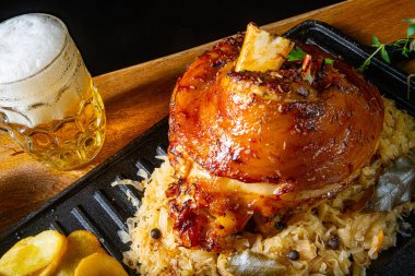 Lahana turşulu domuz budu, tatlı hardal ve kızarmış patates.