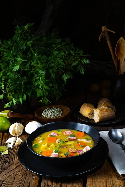 Domuz pastırması, sosis ve yakın çekim manzaralı kırsal bezelye çorbası.