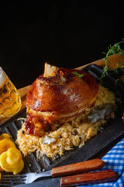 Lahana turşulu domuz budu, tatlı hardal ve kızarmış patates.