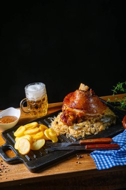 Lahana turşulu domuz budu, tatlı hardal ve kızarmış patates.