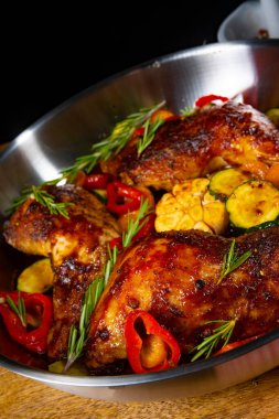 Çeşitli sebze ve baharatlarla kızarmış tavuk bacağı.