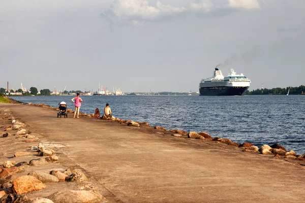 Famiglie con un bambino che guarda dalla riva per la vela cr — Foto Stock