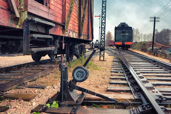 Vecchia locomotiva e auto su una stazione ferroviaria — Foto Stock