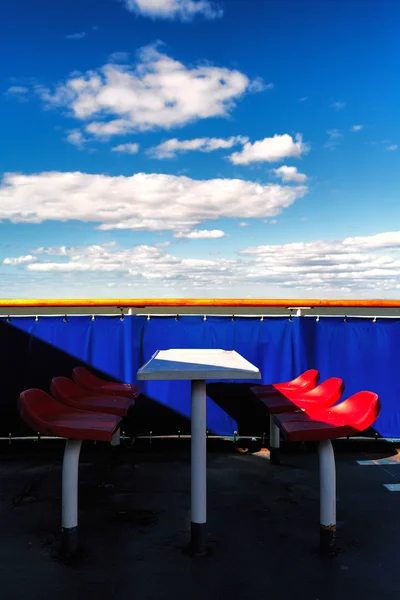 Red chairs on a blue background on the ferry in the spring — Stock Photo, Image