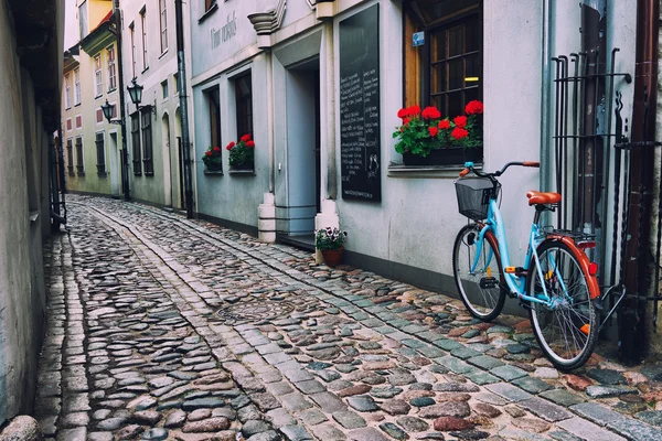 Bicikli régi utcán, Rigában Stock Fotó