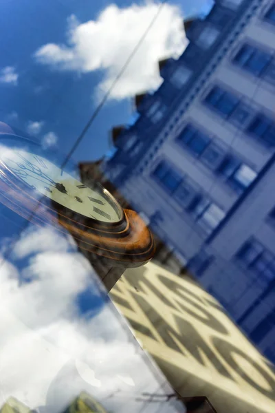 Spiegelung von Häusern im Fenster mit der Uhr — Stockfoto