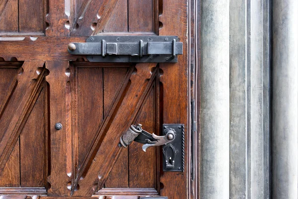 Old door handle on wooden door and a steel bolt — Stock Photo, Image