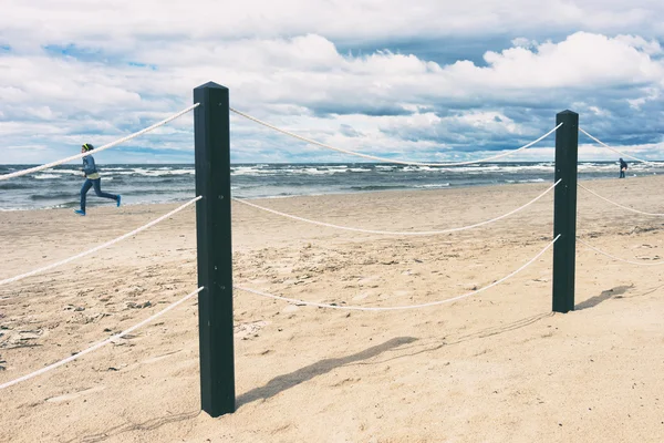 Jenta løper langs stranden ved Østersjøen. – stockfoto