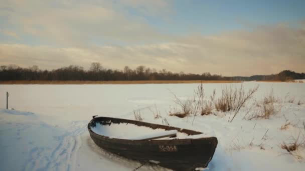 सर्दियों में एक जमे हुए नदी द्वारा लकड़ी की नाव — स्टॉक वीडियो
