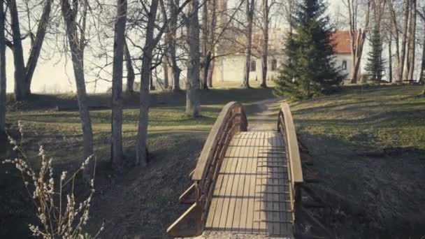 Překročení dřevěného mostu na začátku jara — Stock video