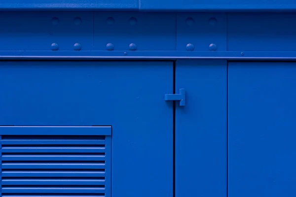 Blauw geschilderde ijzeren muur met deur — Stockfoto