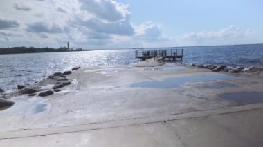 İnsanlar, Daugava Nehri 'nin barajındaki iskelede, ağzındaki deniz fenerine kadar dinleniyorlar. Nehir, Baltık Denizi 'nin Riga Körfezi' ne akar. Riga sakinleri için popüler bir tatil yeri