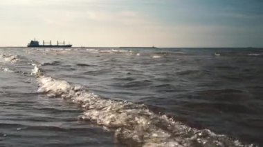 Tekne, yaz aylarında Baltık Denizi 'nde, gün batımında küçük dalgaların arka planında yüzer.