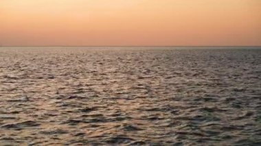 Tekne, yaz aylarında Baltık Denizi 'nde, gün batımında küçük dalgaların arka planında yüzer.