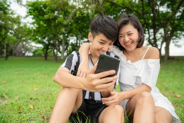 Feliz Rindo Asiático Lésbicas Casal Sentado Livre Parque Usar Telefone — Fotografia de Stock