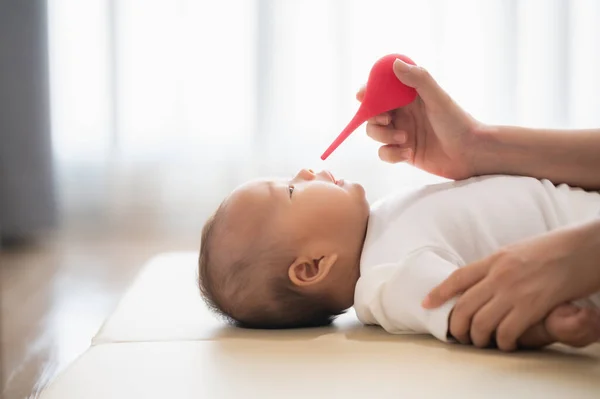 鼻吸引器や注射器ボールで新生児の鼻を掃除する母親 — ストック写真