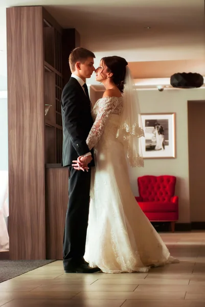 Happy bride and groom is standing in the hotel — Stock Photo, Image