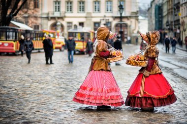 two woman in traditional clothes standing in the square in old city Lvov clipart