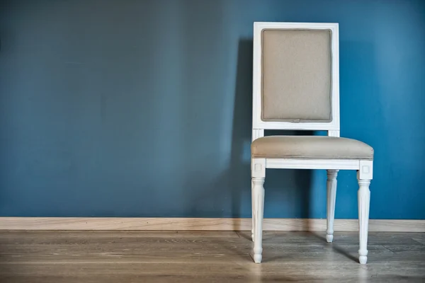 Cadeira branca perto da parede azul — Fotografia de Stock