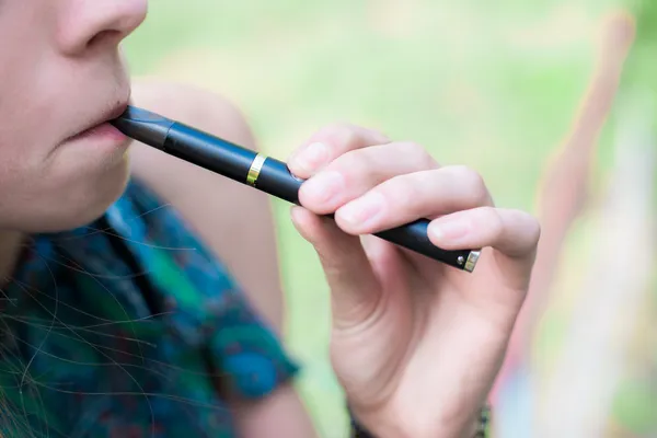 Woman smoking electronic cigarette outdoors — Stock Photo, Image