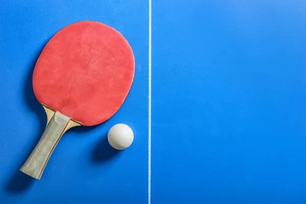 Pin pong bola com remo vermelho na placa azul — Fotografia de Stock