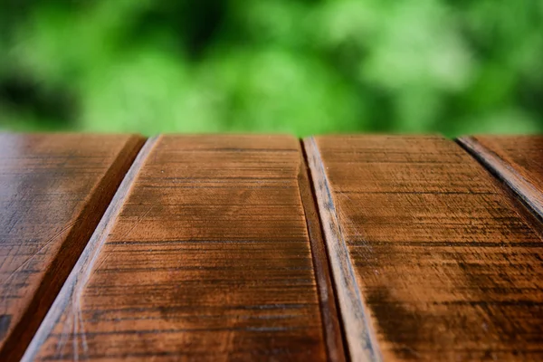 Dřevěný stůl a zelený dvůr — Stock fotografie