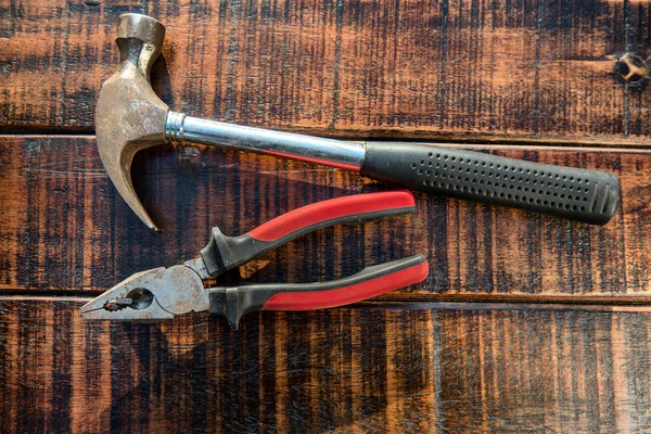 Hammer und Zange auf Holzgrund — Stockfoto