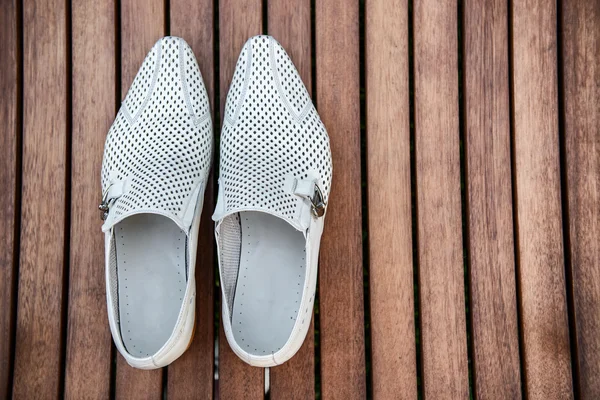 Männliche weiße Schuhe über dem Holztisch — Stockfoto
