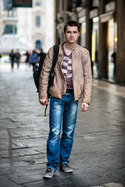 Hombre caminando por la calle de la ciudad con una bolsa — Foto de Stock