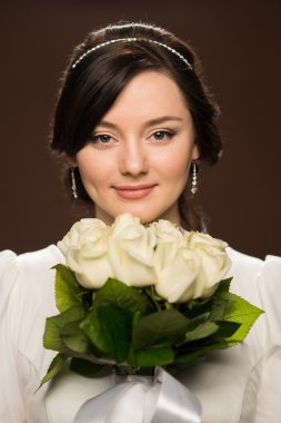 genç ve güzel bir gelin düğün buket ile stüdyo portresi.