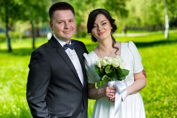 Gelukkige bruid en bruidegom buiten op het groene park — Stockfoto