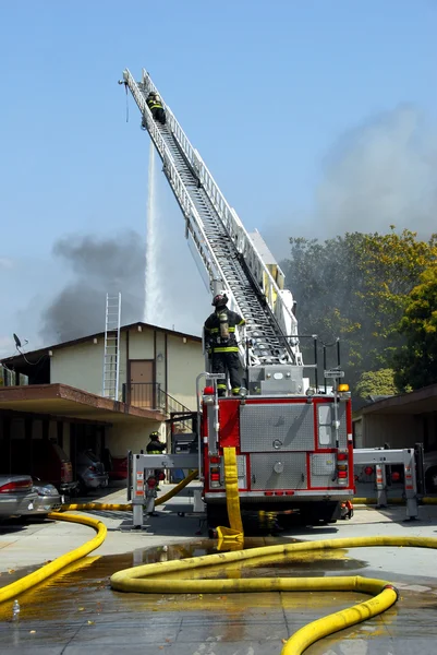 Pompiers travaillant un incendie Aopartment Image En Vente