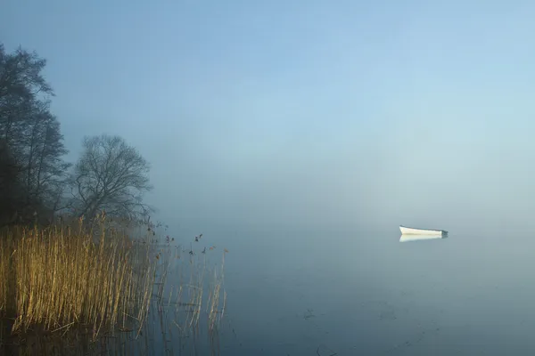 Łódź na jeziorze we mgle — Zdjęcie stockowe