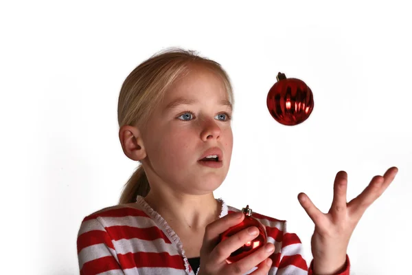 Girl juggling with red Cristmas toy — Stock Photo, Image