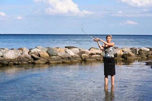 Söt blond tjej leker med vatten — Stockfoto