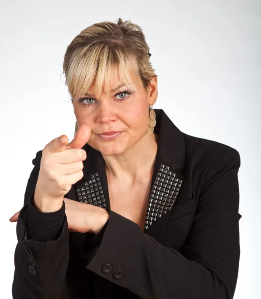 Studio portrait of a cute blond girl pointing with her finger — Stock Photo, Image