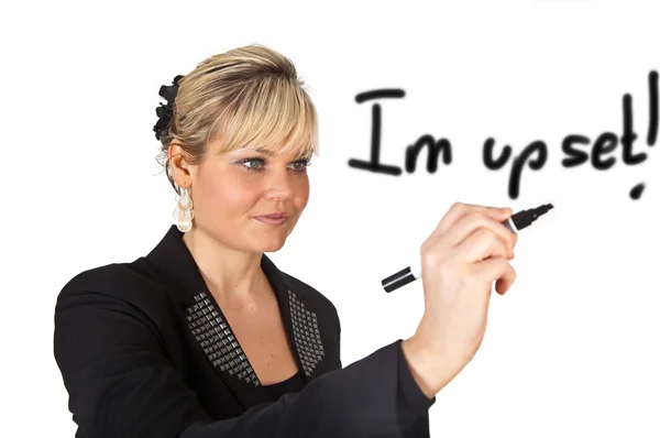 Studio portrait of a cute blond girl writing on a transparent wa — Stock Photo, Image