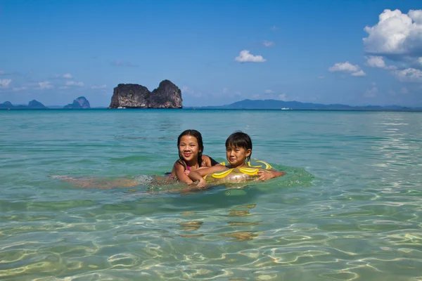 Twee meisjes zwemmen in het water — Stockfoto