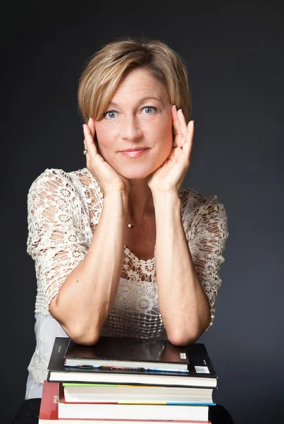 Woman elbows on books — Stock Photo, Image