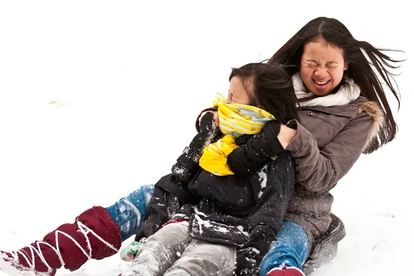 Two sisters sledging holding each other — Stock Photo, Image