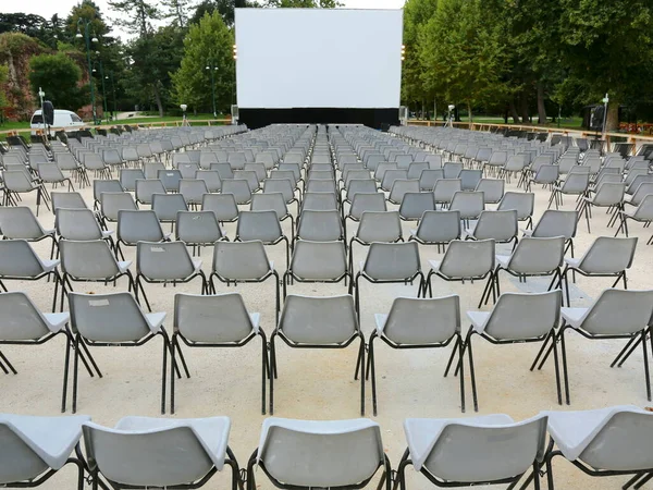 户外电影院在一个有很多椅子的公园里放映 放映前放映大屏幕 — 图库照片