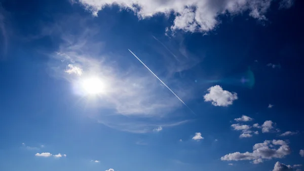 Jet vliegtuig in een zonnige blauwe hemel Stockfoto