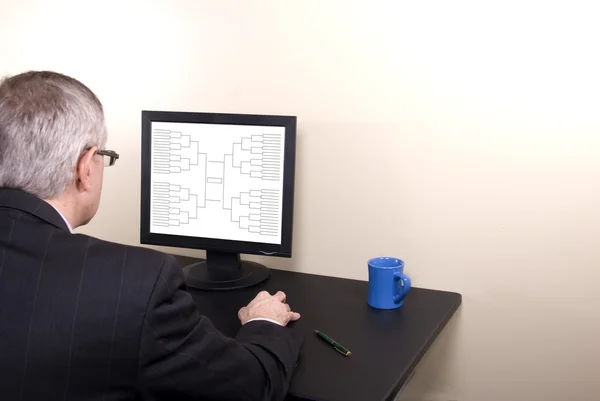 March Madness Business Man in Suit Looking at Bracket on Monitor — Stock Photo, Image