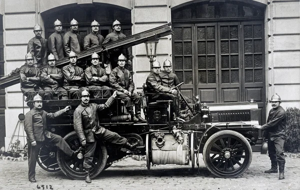 Velho cartão postal de um grupo de bombeiros em um caminhão — Fotografia de Stock