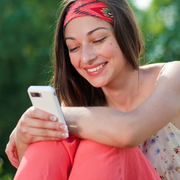 Young happy teenage girl reading message on mobile — Stock Photo, Image