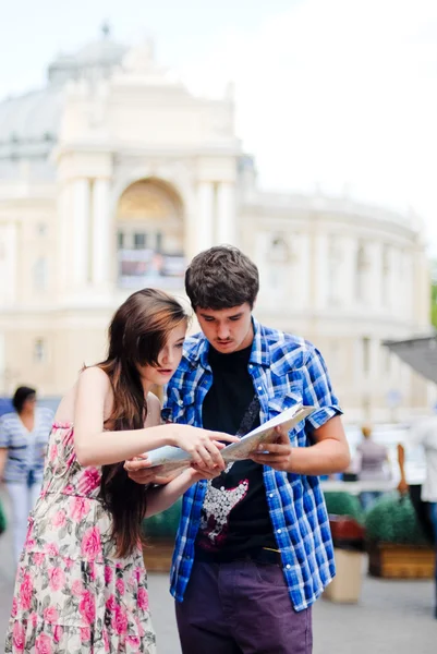年轻夫妇在城市中心的地图上查找和显示方向 — 图库照片