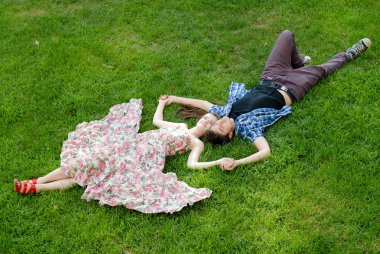 küçük mutlu bir çift erkek ve kadın yeşil çim üzerinde yalan