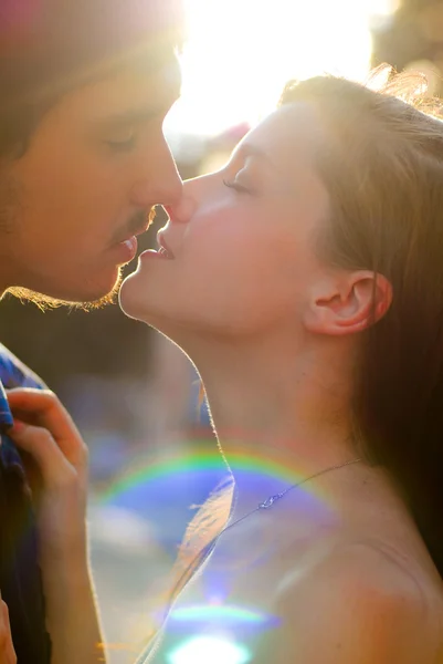 Jovem casal feliz homem e mulher beijando clarão — Fotografia de Stock