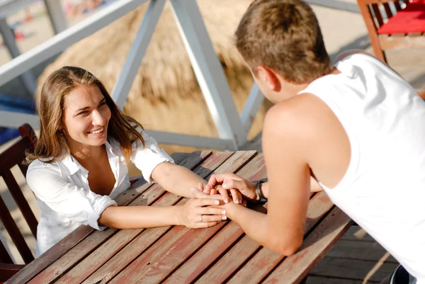 Jonge gelukkige paar man en vrouw zitten in café — Stockfoto