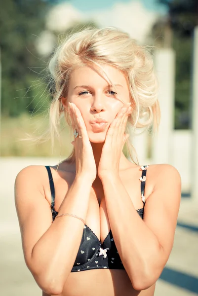 Young beautiful blond woman touching cheeks and put lips in kiss — Stock Photo, Image